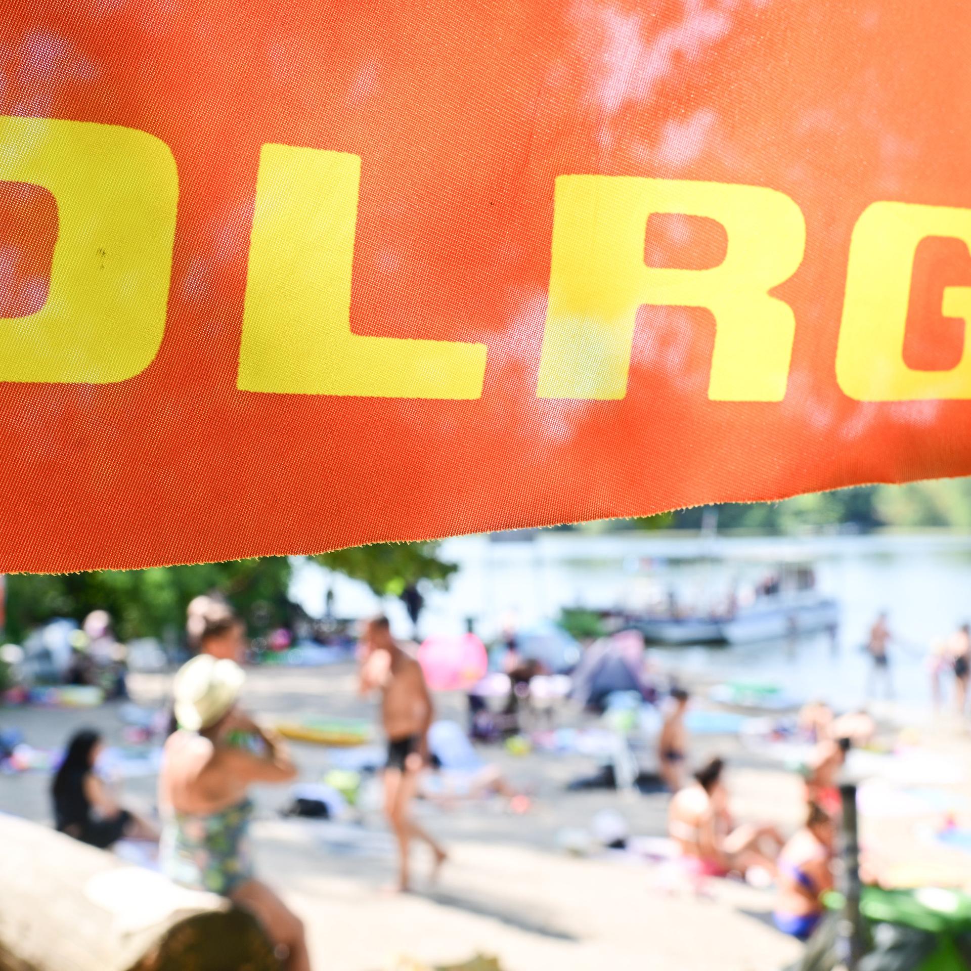 Ein Fahne der Deutschen Lebens-Rettungs-Gesellschaft weht am Tegeler See in Berlin an einer Badestelle. 