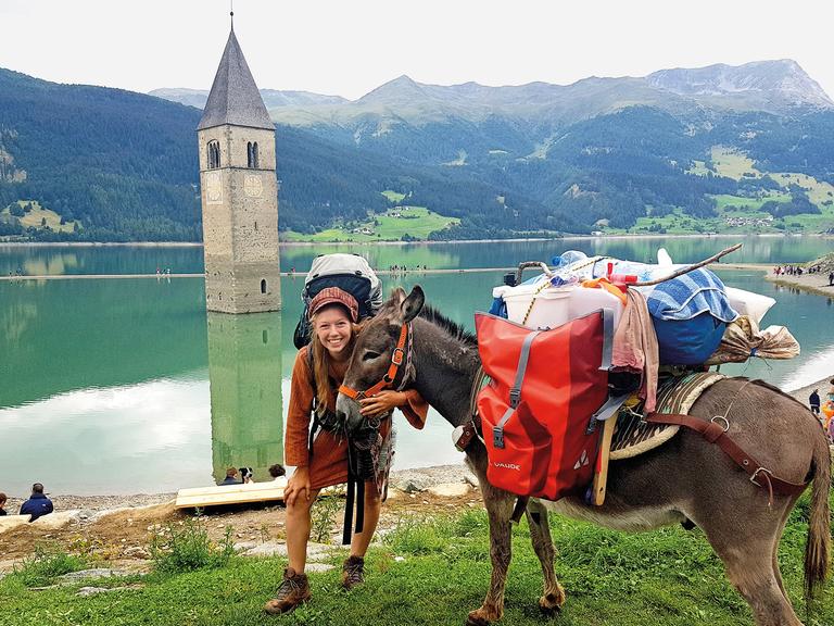 Lotta unterwegs auf ihrer Wanderung mit ihrem Esel Johnny, das Gepäcktragen teilen sie sich.