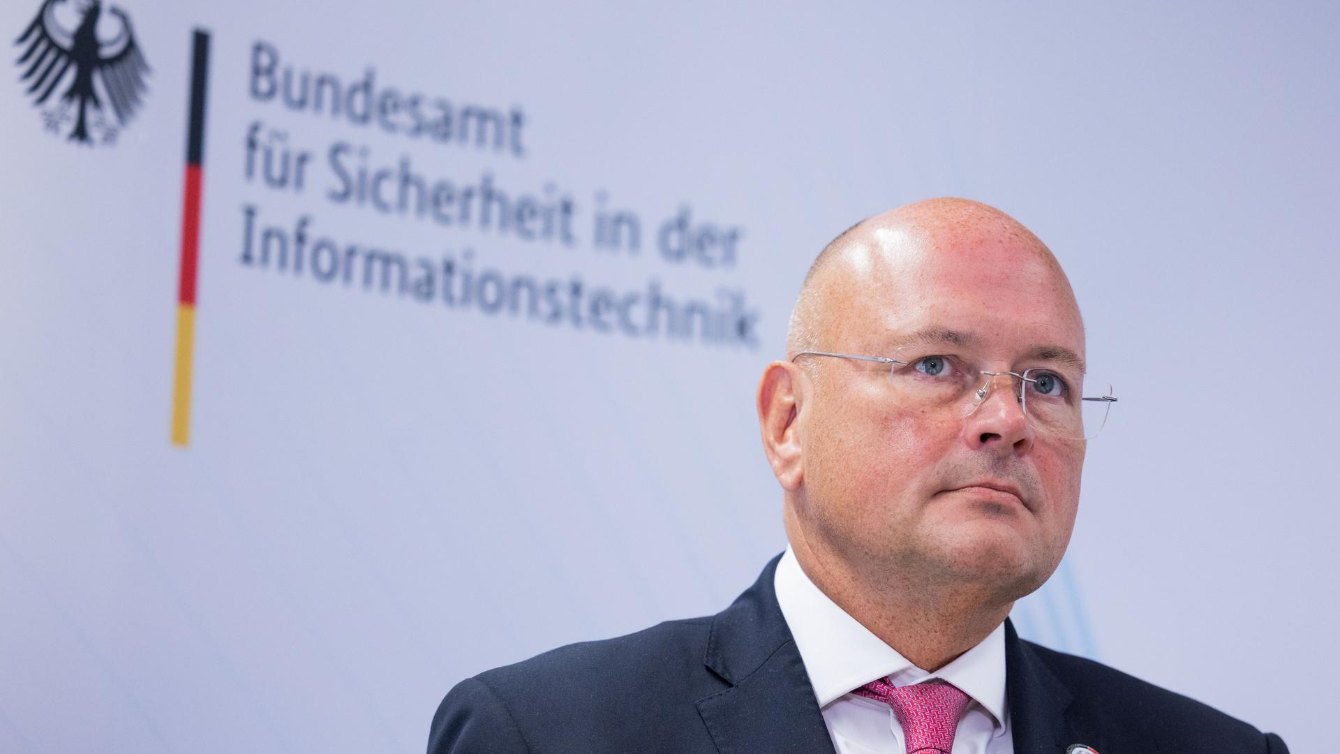 Arne Schönbohm, Präsident des Bundesamtes für Sicherheit in der Informationstechnik (BSI), steht bei einem Besuch der Bundesinnenministerin vor einem Schriftzug.