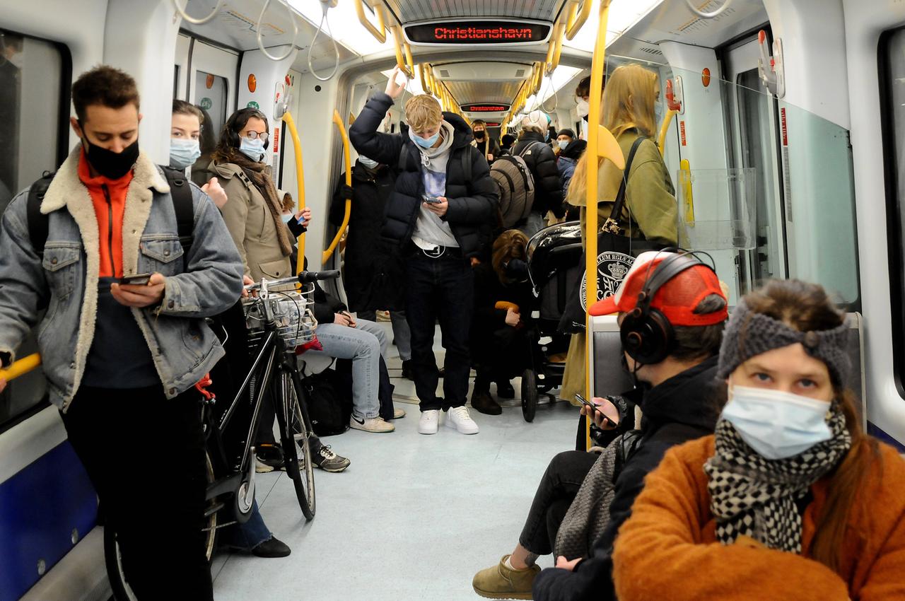 Menschen stehen und sitzen am 18. Januar in einer U-Bahn in Kopenhagen und tragen eine Corona-Schutzmaske. 
