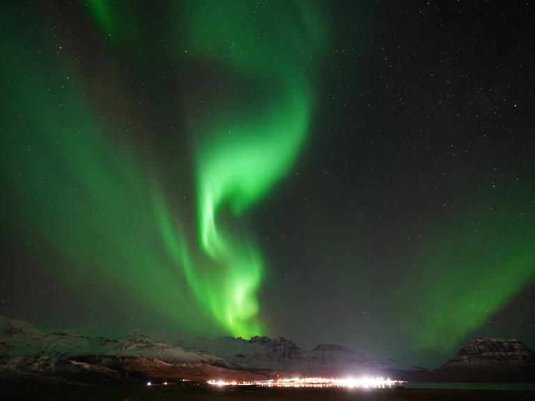Großes grünes Nordlicht am Himmel über der nächtlichen Küste von Island in der Nähe der Stadt Grundarfjordur