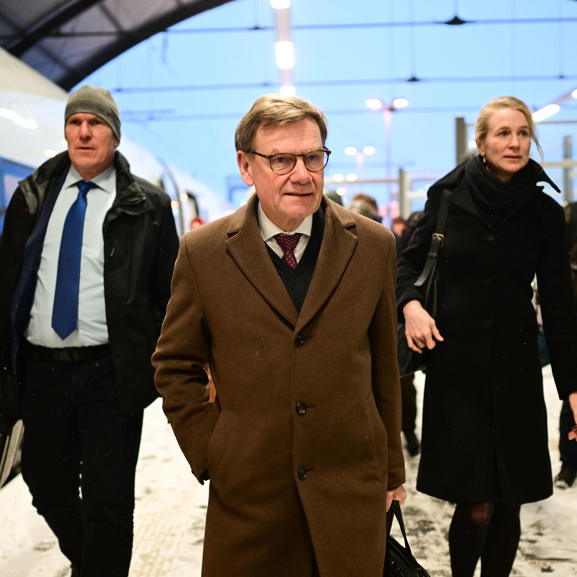 Johann Wadephul (CDU), Außenminister, wird von mehreren Personen an einem Bahnhof begleitet. 