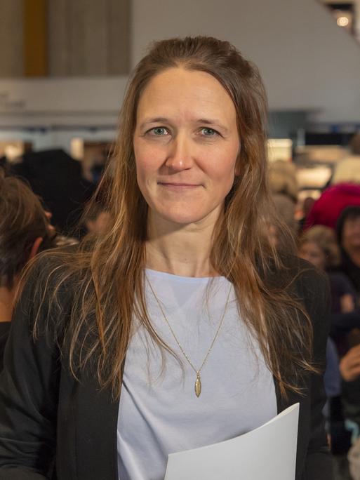 Martina Clavadetscher steht bei einer Lesung vor dem Publikum.