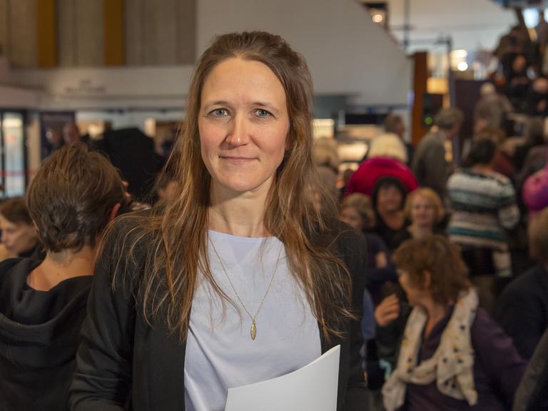 Martina Clavadetscher steht bei einer Lesung vor dem Publikum.