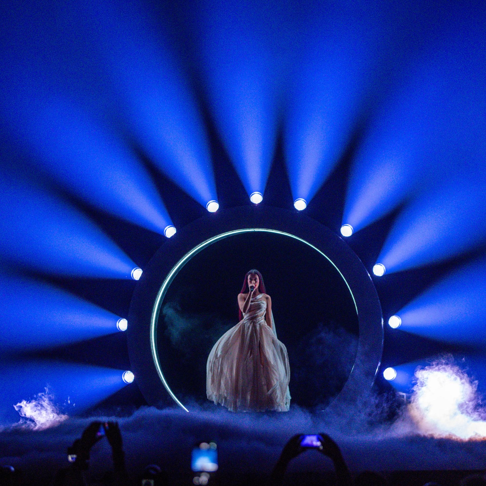 Eden Golan aus Israel auf der Bühne des Eurovision Song Contest in Malmö. Sie steht in einem blauen Lichterkreis, der Boden ist mit Nebel bedeckt.