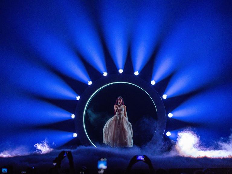 Eden Golan aus Israel auf der Bühne des Eurovision Song Contest in Malmö. Sie steht in einem blauen Lichterkreis, der Boden ist mit Nebel bedeckt.