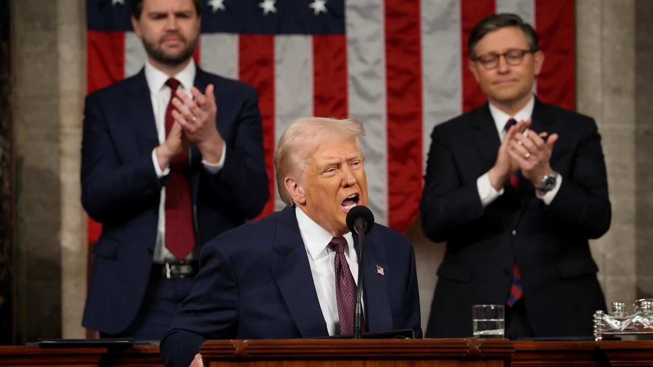 US-Präsident Donald Trump steht an einem Rednerpult im Kongress, im Hintergrund stehen Vize-Präsident Vance und der Haussprecher Mike Johnson vor einer amerikanischen Flagge und applaudieren