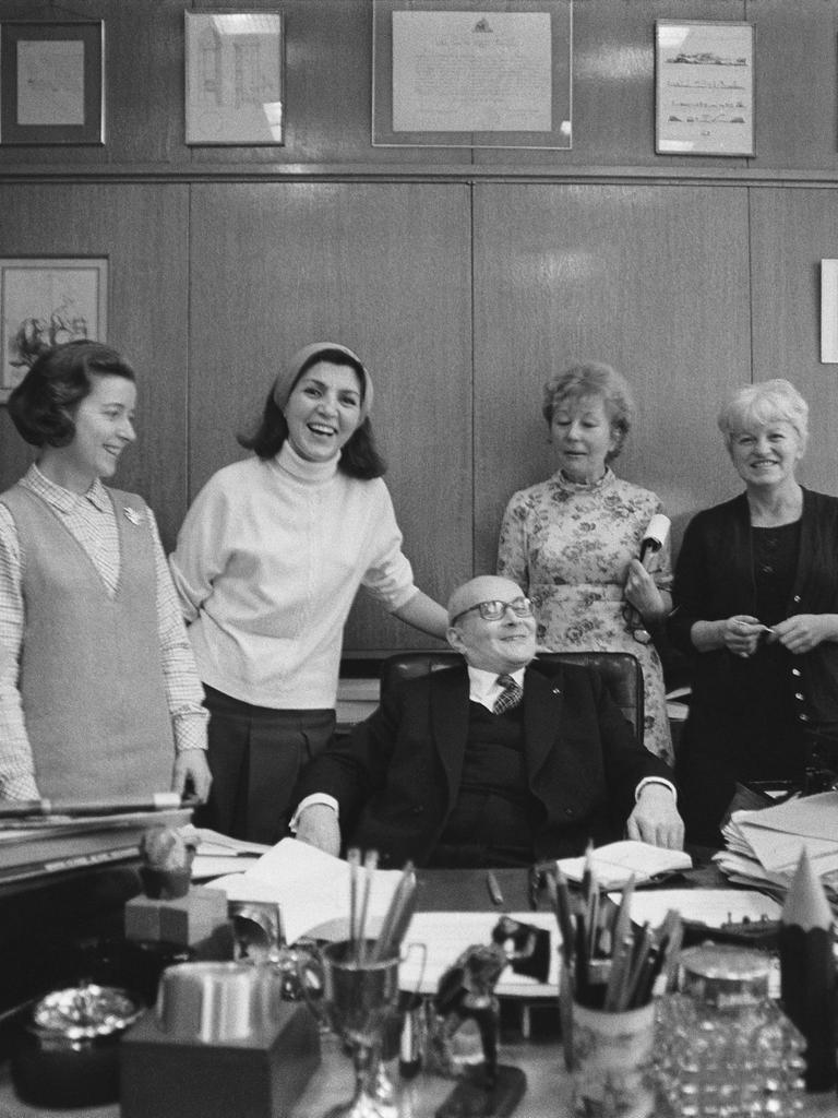 Der französische Journalist Pierre Lazareff sitzt im Jahr 1970 an seinem Schreibtisch, während seine sechs Sekretärinnen ihn umrunden.