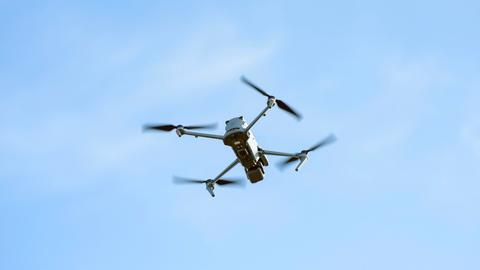 Eine unbemannte Drohne fliegt am Himmel.