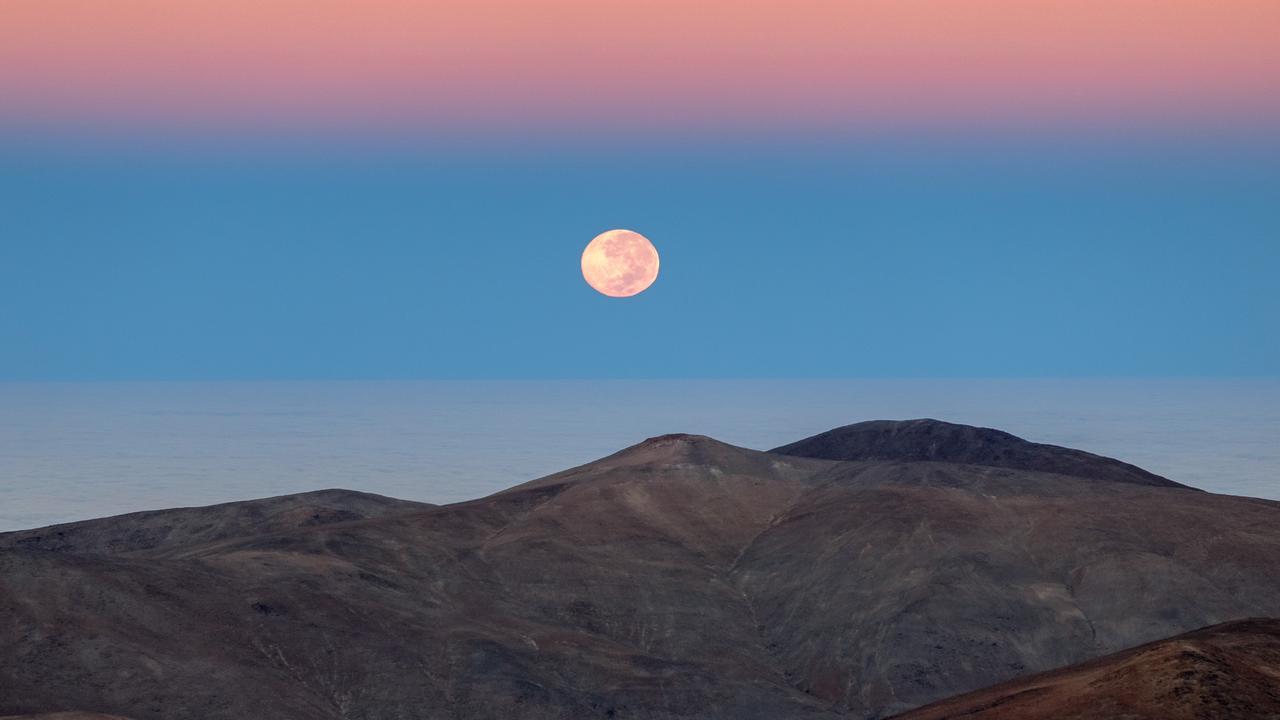 Das Bild zeigt den Mond über einem Berg in der Atacama-Wüste.
