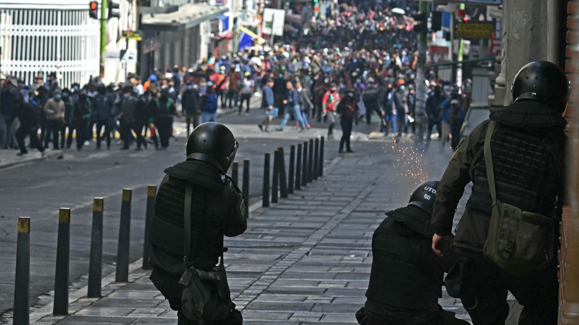 Das Foto zeigt Bereitschaftspolizisten, die mit Tränengas gegen Protestierende in der bolivianischen Verwaltungshauptstadt La Paz vorgehen.