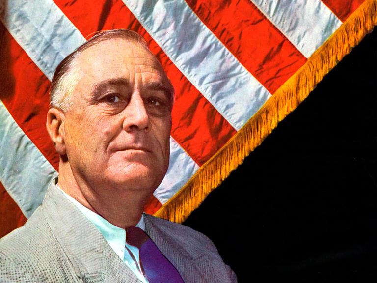 Farbiges Porträt von Franklin D. Roosevelt, der vor einer amerikanischen Flagge sitzt. Farbiges Porträt von Franklin D. Roosevelt, der vor einer amerikanischen Flagge sitzt.