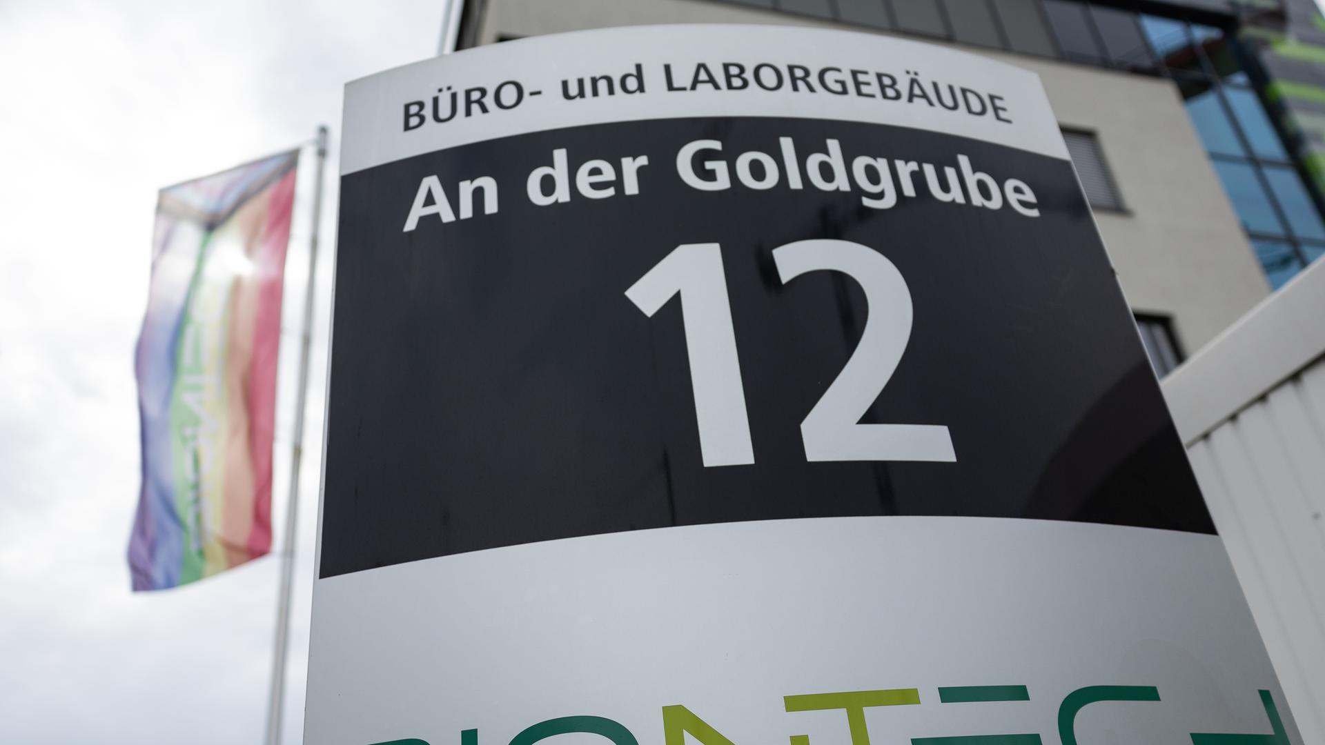 Firmenschild des Unternehmens Biontech mit Flagge im Hintergrund. Firmenschild des Unternehmens Biontech mit Flagge im Hintergrund.