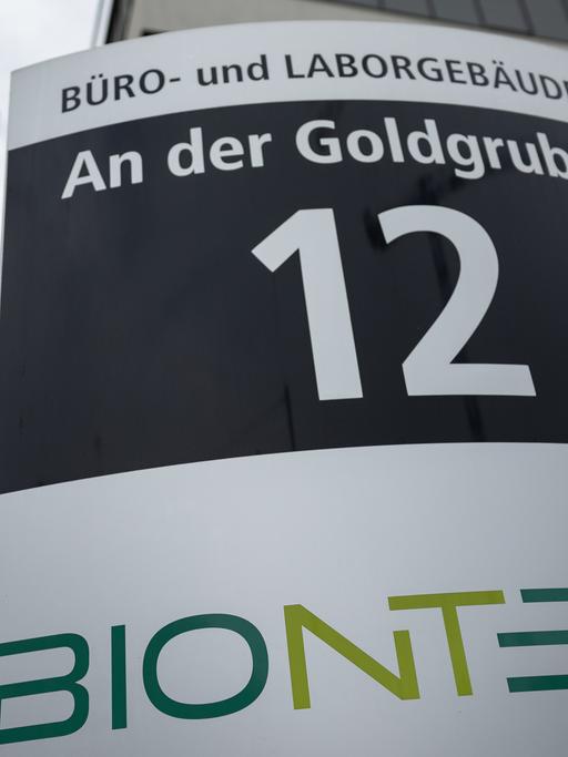 Firmenschild des Unternehmens Biontech mit Flagge im Hintergrund. Der rheinland-pfälzische Wissenschaftsminister Clemens Hoch sieht Rheinland-Pfalz bei der Entwicklung zu einem führenden Standort in der Biotechnologie auf einem guten Weg.