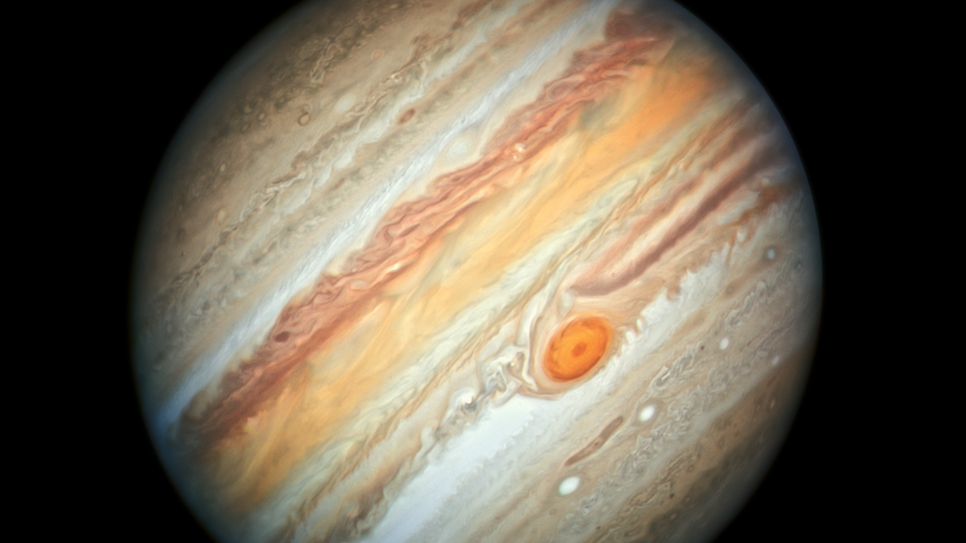 Aufnahme des orange-weißen Riesenplanets Jupiter im vor einem schwarzen Hintergrund.