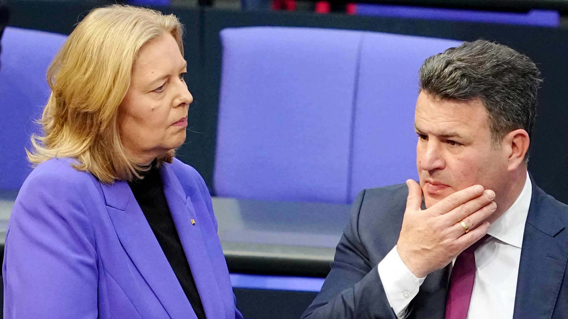 Bärbel Bas (li.) und Hubertus Heil (re.) stehen im Plenum des Bundestags beieinander. Bärbel Bas (li.) und Hubertus Heil (re.) stehen im Plenum des Bundestags beieinander.