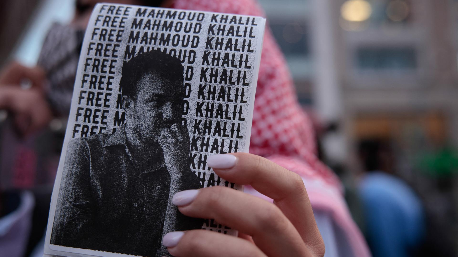 Auf einem Zettel, den jemand in der Hand hält, sieht man das Bild von Mahmoud Khalil, einem pro-palästinensischen Aktivisten in den USA. Im Hintergrund steht: Free Mahmod Khalil". Auf einem Zettel, den jemand in der Hand hält, sieht man das Bild von Mahmoud Khalil, einem pro-palästinensischen Aktivisten in den USA. Im Hintergrund steht: Free Mahmod Khalil".