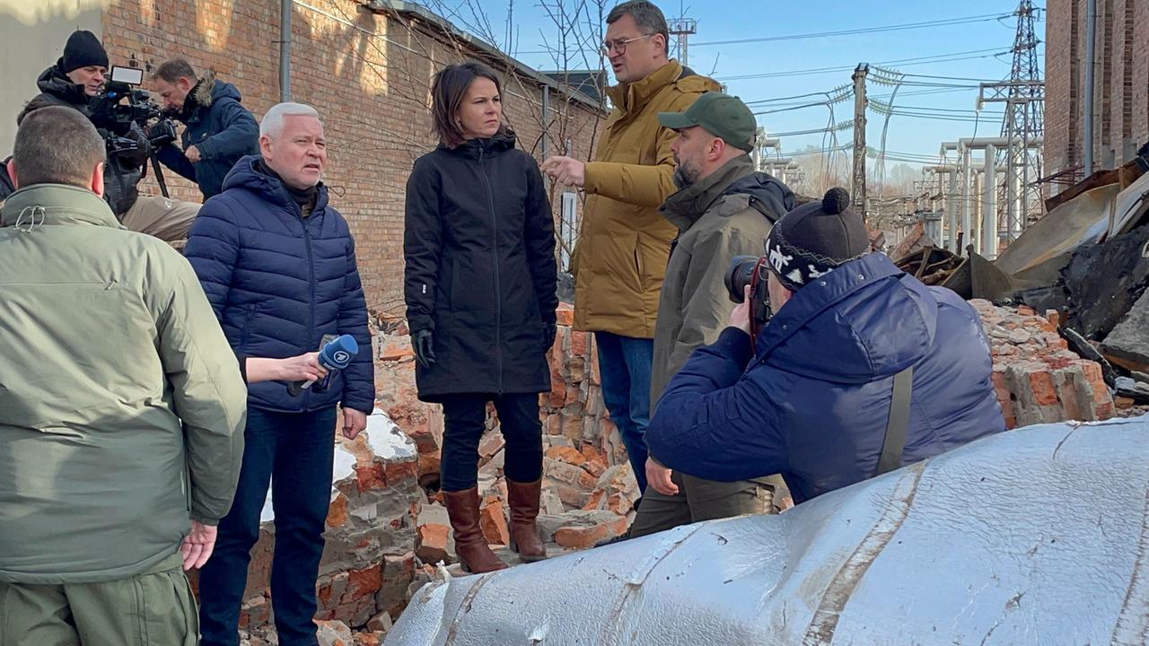 Außenministerin Annalena Baerbock (Bündnis 90 / Die Grünen) steht während ihrer Reise in die Ostukraine neben dem ukrainischen Außenminister Dmytro Kuleba (3.v.r), dem Gouverneur von Charkiw, Oleh Synehubow (2.v.r) und dem Bürgermeister von Charkiw, Ihor Terechow (5.v.r) in Charkiw auf dem Gelände eines den Russen zerstörten Umspannwerkes. 