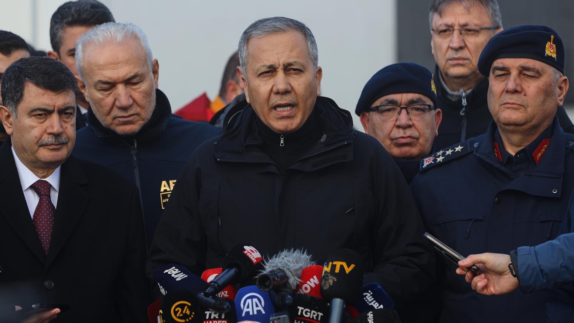 Der türkische Innenminister Ali Yerlikaya (M) spricht zu den Medien. Neben ihm stehen mehrere Personen. 