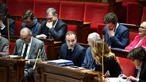Lecornu sitzt in der Nationalversammlung zwischen anderen Politikern.