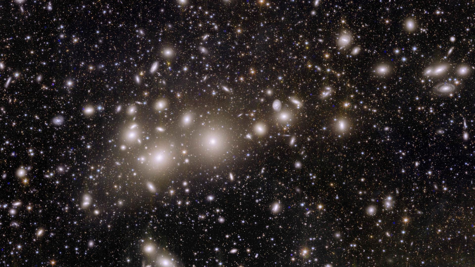 Galaxien des sogenannten Perseushaufens sind als Lichtpunkte im dunklen All zu sehen.