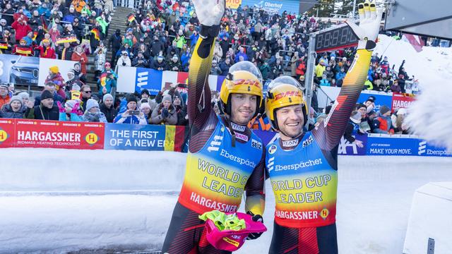 Die Rennrodler Tobias Wendl und Tobias Arlt stehen nebeneinander und freuen sich über ihren EM-Titel.