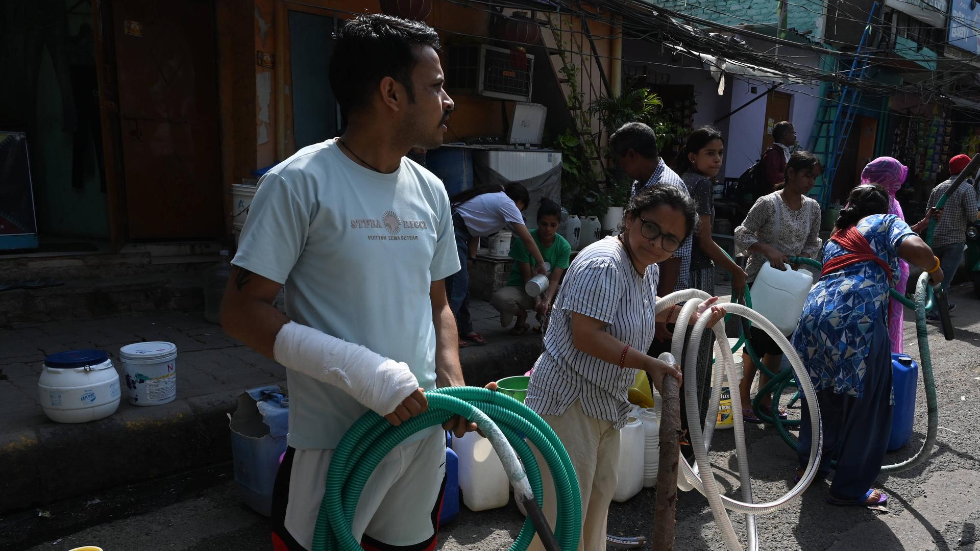 Menschen in Indien füllen sich Wasser in Kanister ab. Menschen in Indien füllen sich Wasser in Kanister ab.