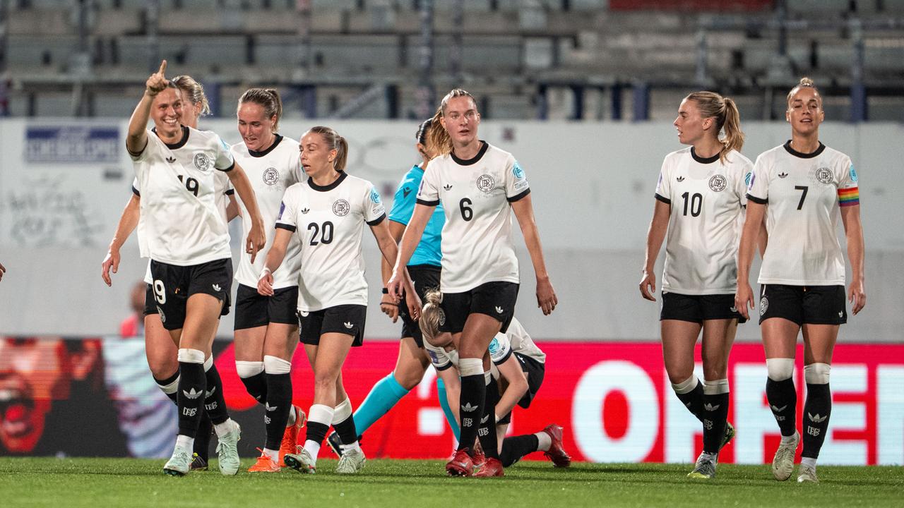 Die deutsche Frauen-Fußballnationalmannschaft auf dem Spielfeld, eine Spielerin hebt den linken Arm und jubelt.