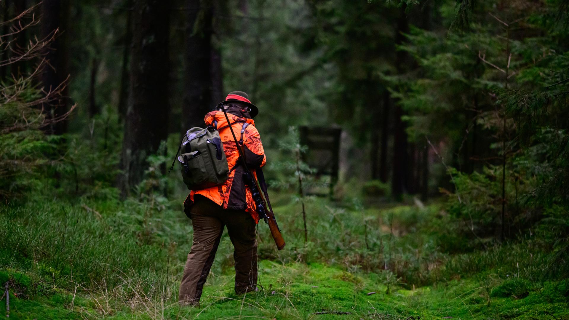 Eine Jägerin geht durch den Wald.