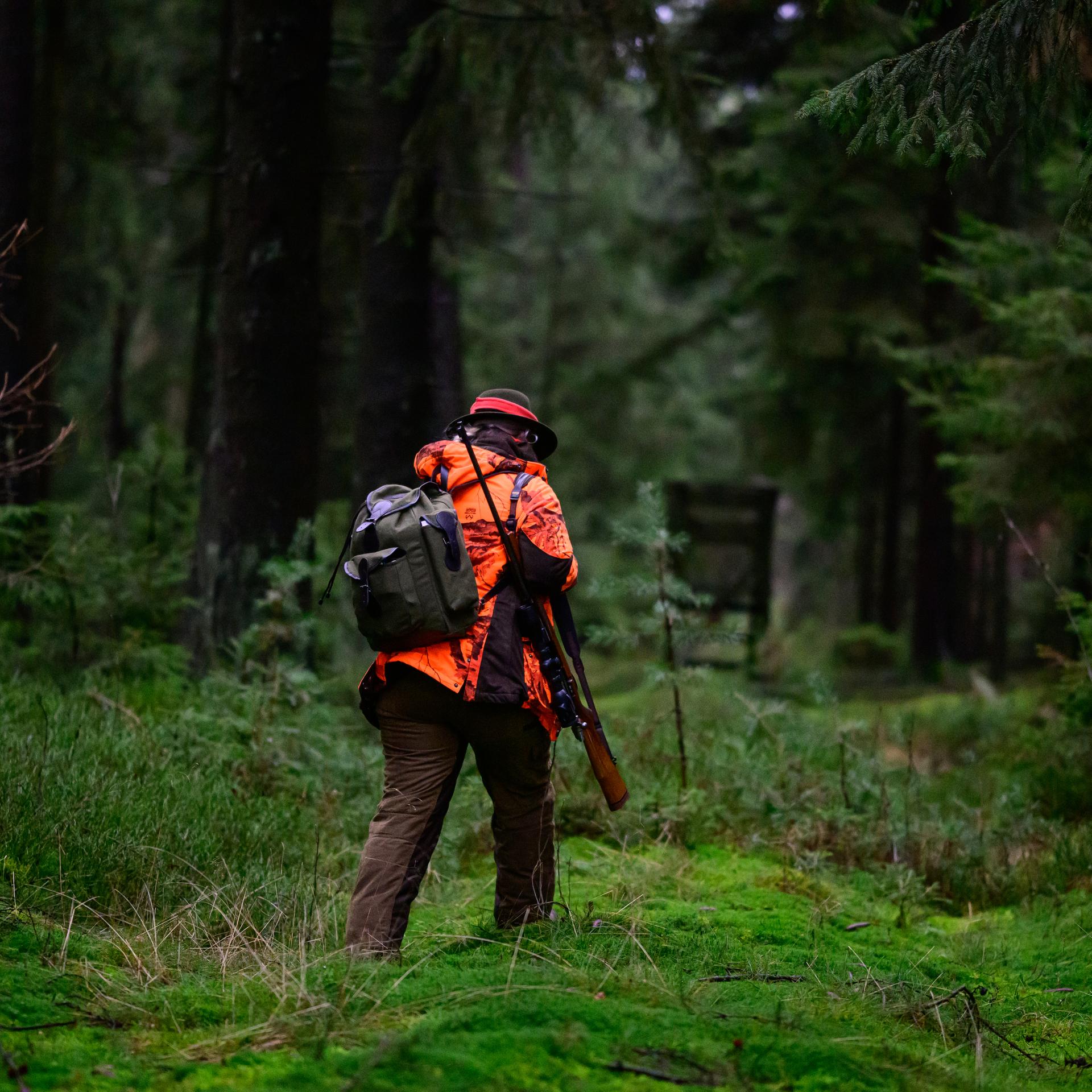 Eine Jägerin geht durch den Wald.