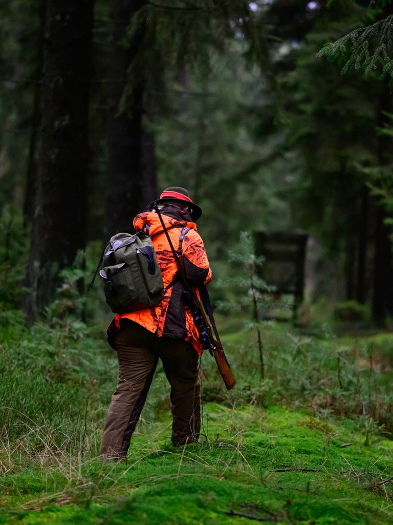Eine Jägerin geht durch den Wald.