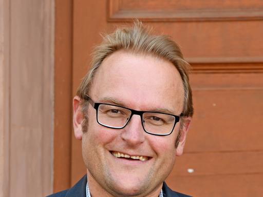 Der Pirmasenser Oberbürgermeister Markus Zwick (CDU) steht vor der Eingangstür des Rathauses. 