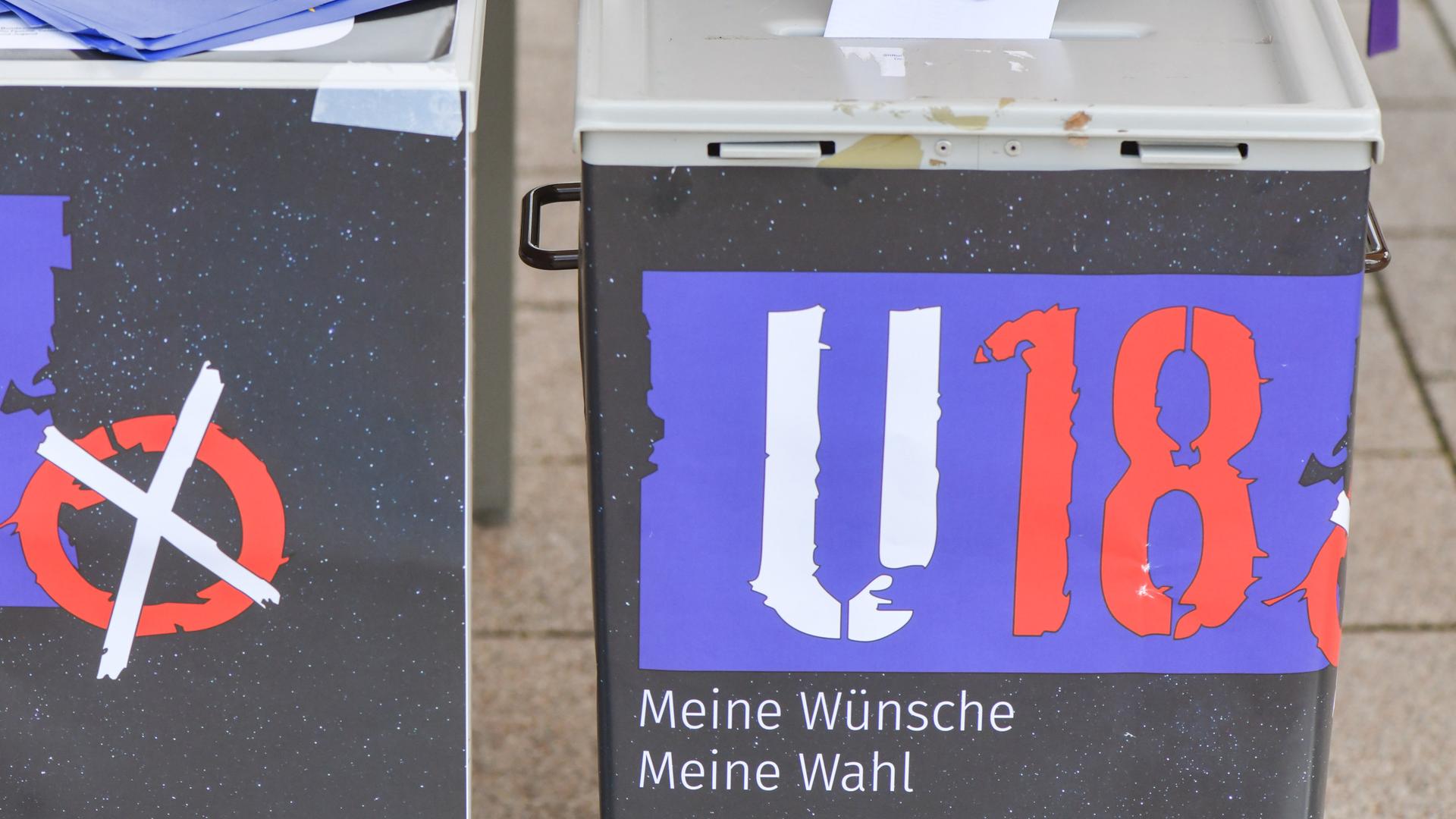 Ein Mädchen steckt ihren Wahlzettel bei der U18-Wahl in eine Wahlurne.