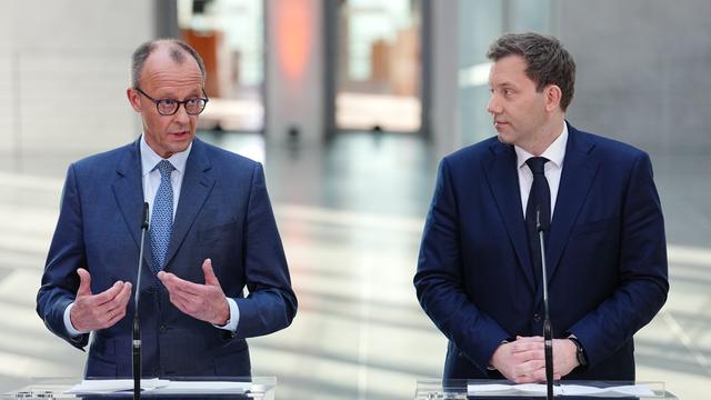 Friedrich Merz, Unions-Kanzlerkandidat und CDU-Bundesvorsitzender und Lars Klingbeil, SPD-Fraktions- und Bundesvorsitzender stehen bei einer Pressekonferenz nach den Sondierungsgesprächen von Union und SPD im Bundestag vor Mikrofonen.