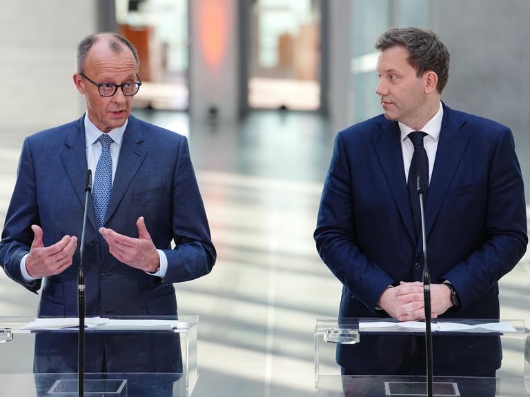 Friedrich Merz, Unions-Kanzlerkandidat und CDU-Bundesvorsitzender und Lars Klingbeil, SPD-Fraktions- und Bundesvorsitzender stehen bei einer Pressekonferenz nach den Sondierungsgesprächen von Union und SPD im Bundestag vor Mikrofonen.