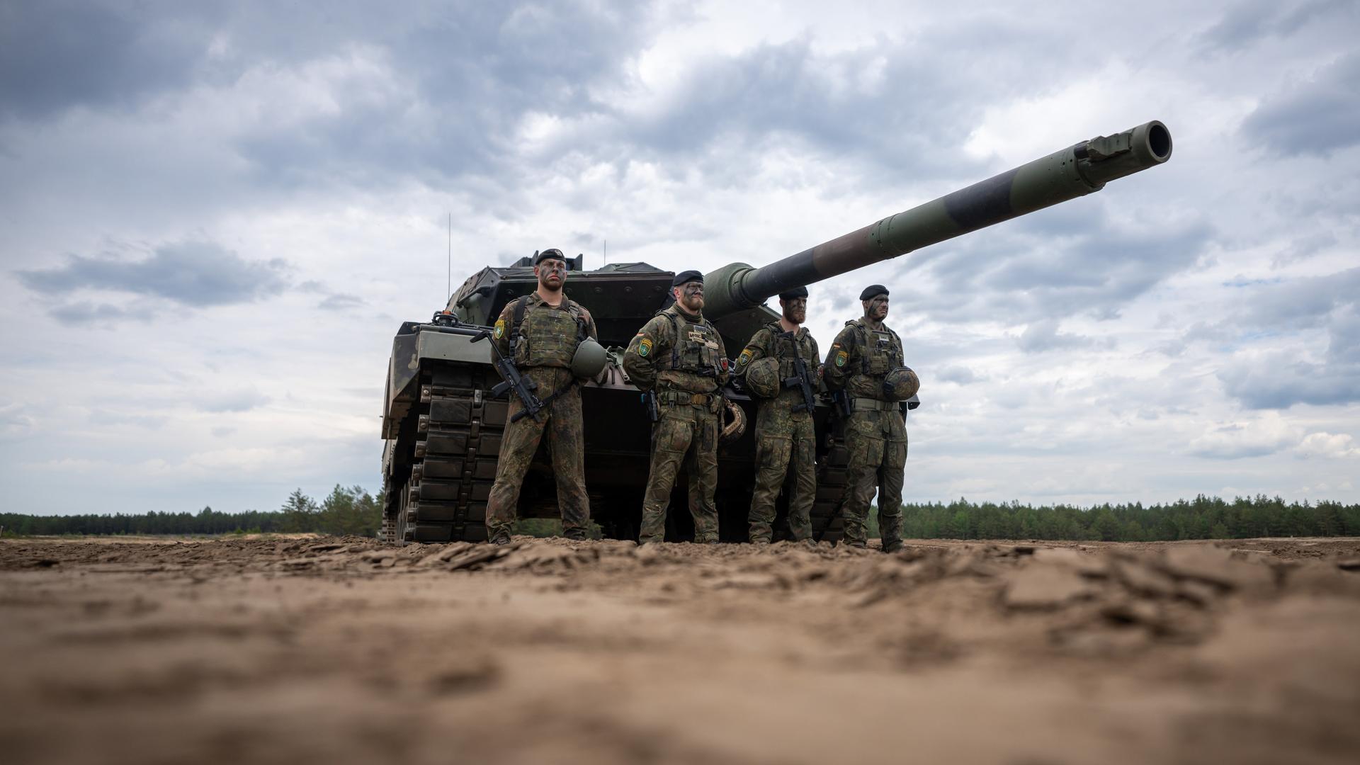 Vier Bundeswehrsoldaten vor einem Leopard-2-Panzer.