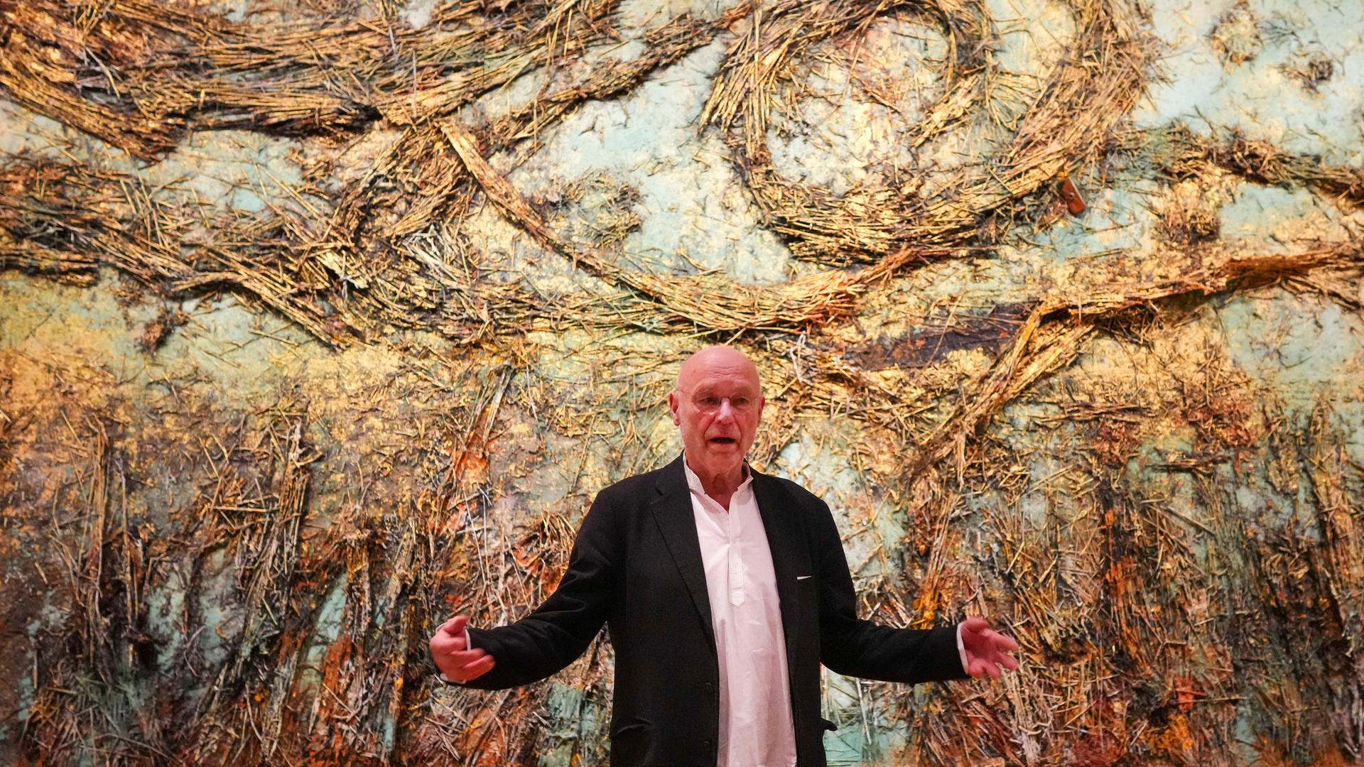 Anselm Kiefer steht am 05.03.2025 vor seinem monumentalen Kunstwerk "Die Sternennacht", das eine surreale Landschaft aus Stroh zeigt.
