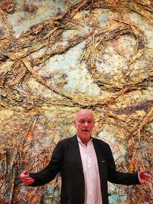 Anselm Kiefer steht am 05.03.2025 vor seinem monumentalen Kunstwerk "Die Sternennacht", das eine surreale Landschaft aus Stroh zeigt.
