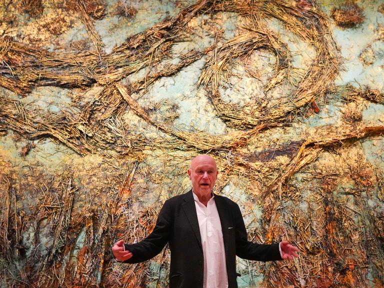 Anselm Kiefer steht am 05.03.2025 vor seinem monumentalen Kunstwerk "Die Sternennacht", das eine surreale Landschaft aus Stroh zeigt.
