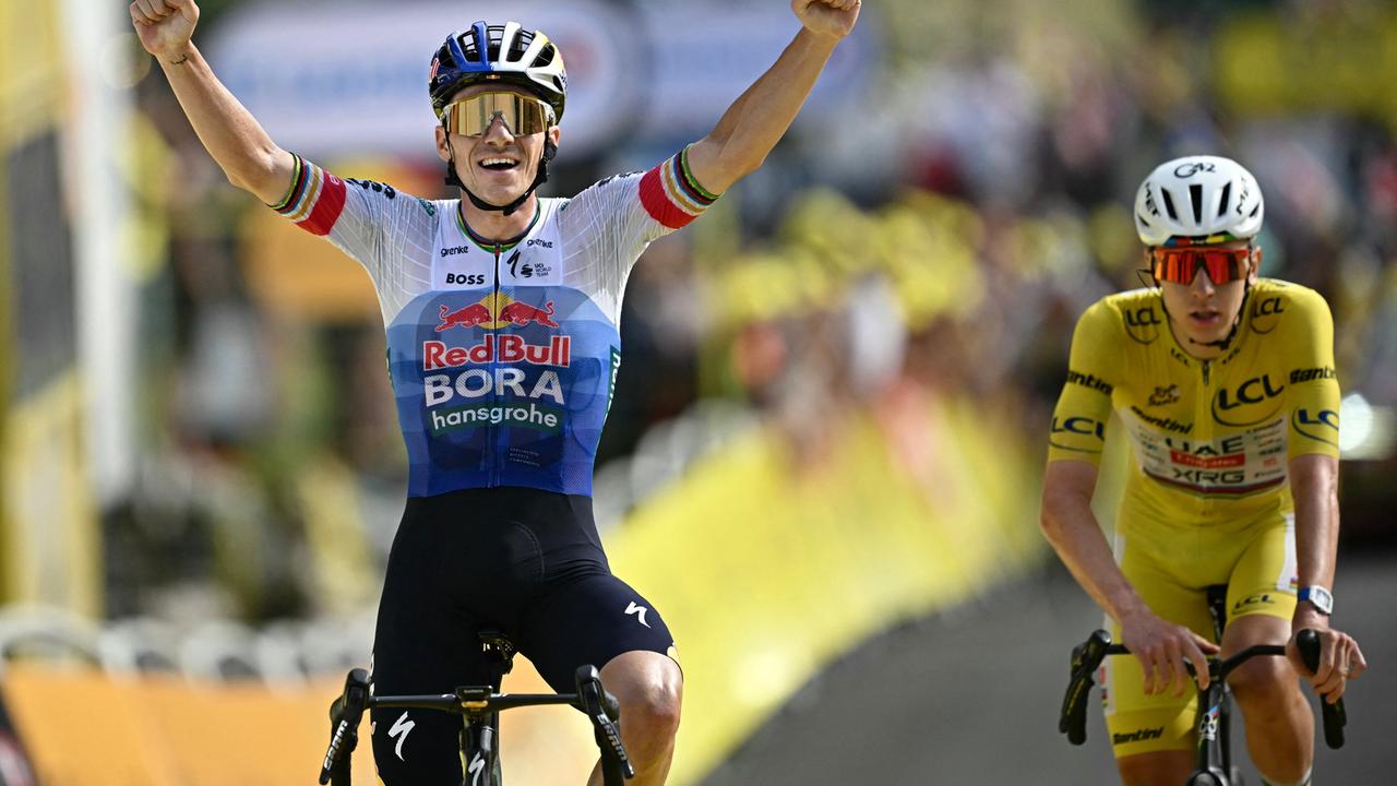 Der belgische Radfahrer Remco Evenepoel fährt als Erster über die Ziellinie und jubelt. Hinter ihm fährt Tadej Pogacar.
