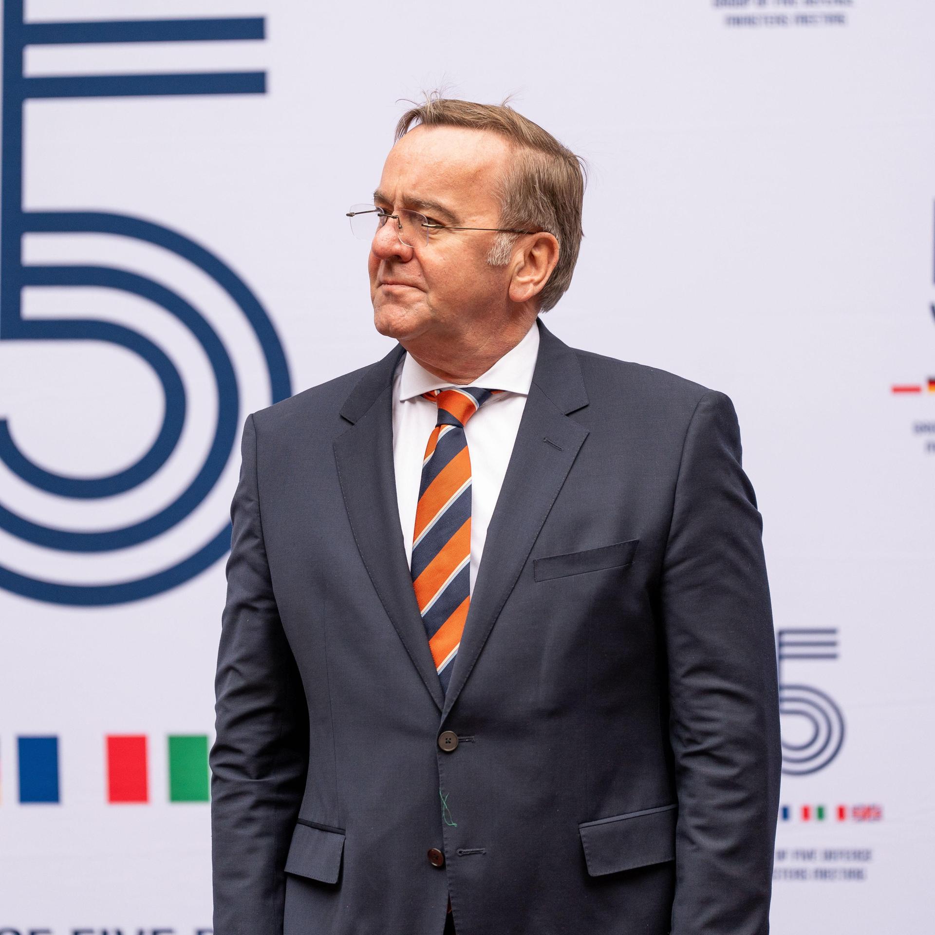 Bundesverteidigungsminister Pistorius steht beim Treffen der E5-Gruppe in Krakau vor einer weißen Wand mit dem Logo der Gruppe.