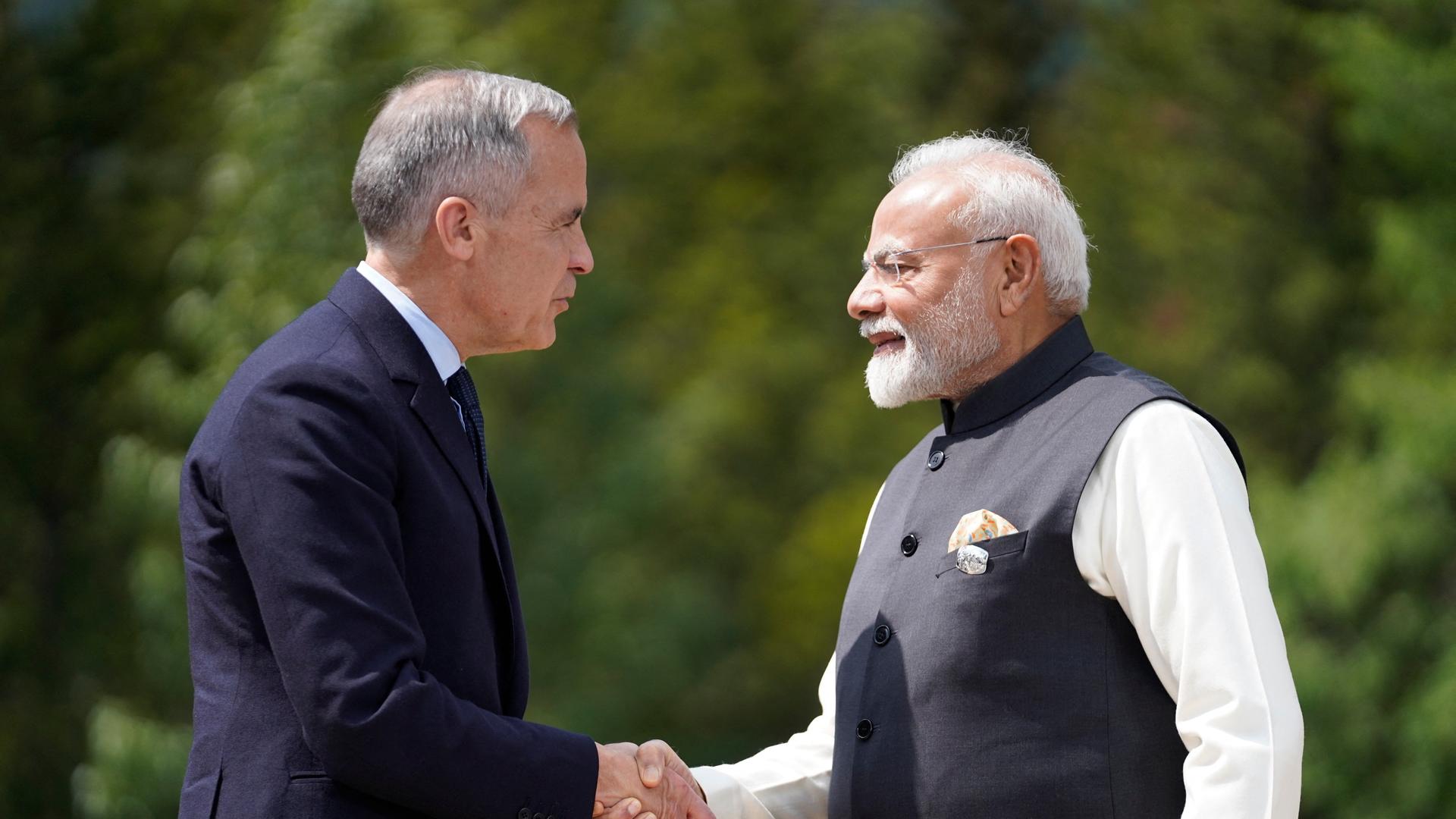 Das Bild zeigt die Staatschefs von Kanada und Indien, Carney und Modi, die sich einander zugewandt die Hände schütteln. 