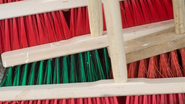 Mehrere Besen mit roten und grünen Borsten