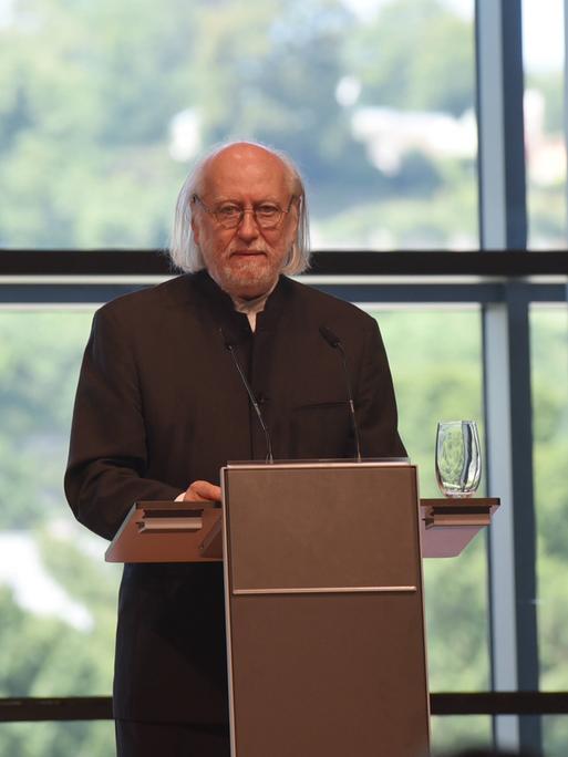 Der ungarische Schriftsteller Laszlo Krasznahorkai steht an einem Rednerpult.