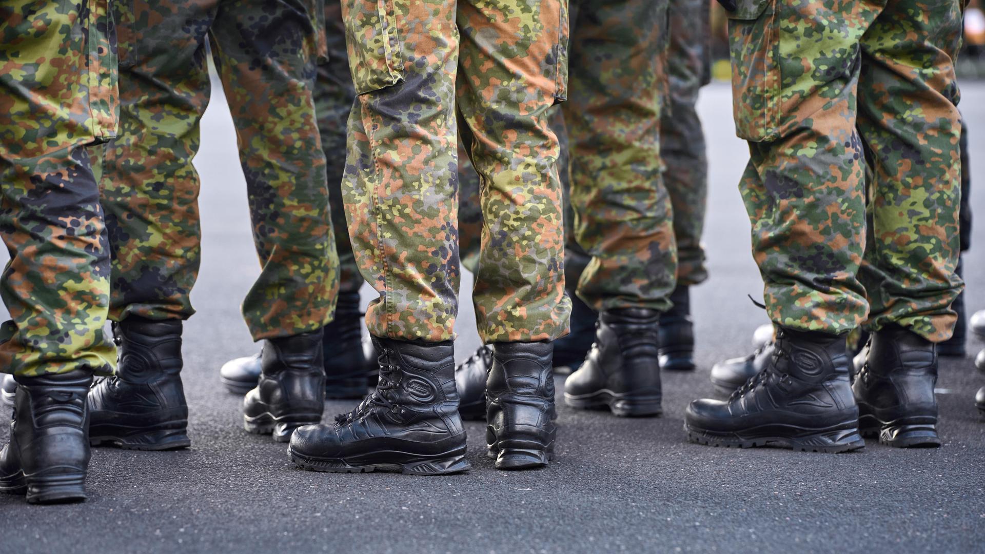 Schwarzen Einsatzstiefel und Tarnhosen von Soldaten der Bundeswehr, die in Formation stehen.