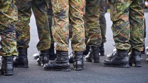 Schwarzen Einsatzstiefel und Tarnhosen von Soldaten der Bundeswehr, die in Formation stehen. Schwarzen Einsatzstiefel und Tarnhosen von Soldaten der Bundeswehr, die in Formation stehen.