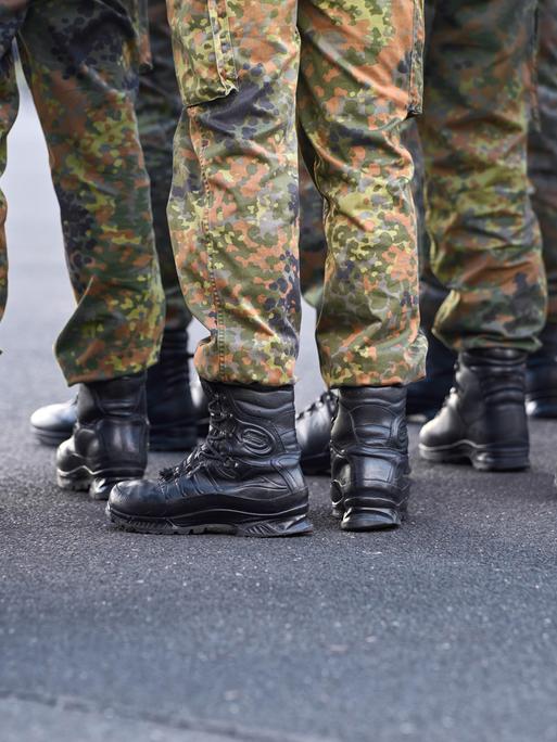 Schwarzen Einsatzstiefel und Tarnhosen von Soldaten der Bundeswehr, die in Formation stehen.