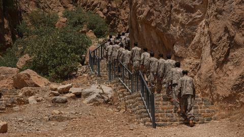 Eine Gruppe von PKK-Kämpfern geht in der Nähe der Stadt Suleimanija eine lange Treppe hinauf.