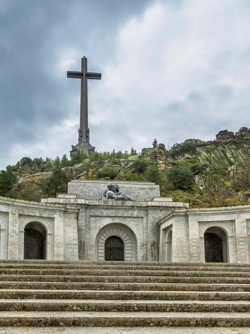 Valle de los Caídos mit einem hoch über felsige Hügel aufragendem Kreuz.