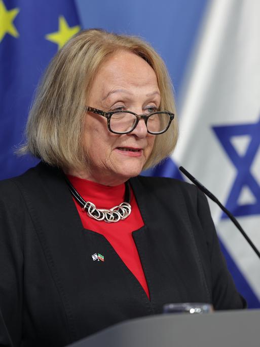 Sabine Leutheusser-Schnarrenberges steht an einem Rednerpult und spricht ins Mikro. Hinter ihr sind die europäische und die israelische Flagge zu sehen.